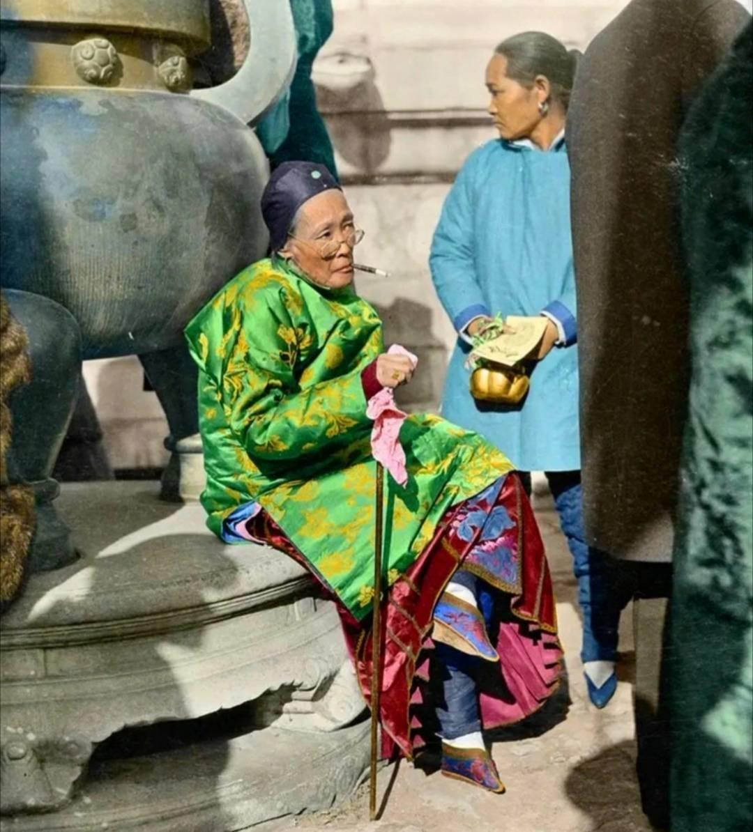 一个裹着小脚的地主婆,盘着二郎腿坐在石座上,嘴里叼着烟拽气十足.