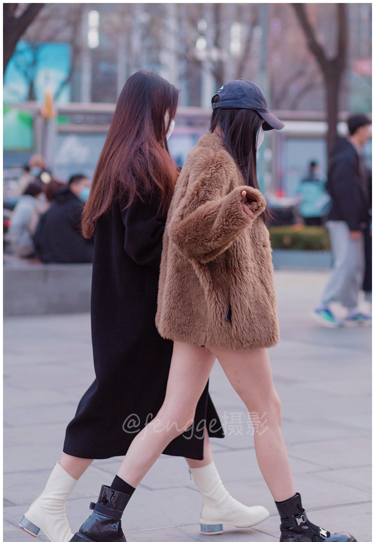 两个美女都是光腿配短靴,貂绒搭短裤或大衣配短裙,都挺时尚的