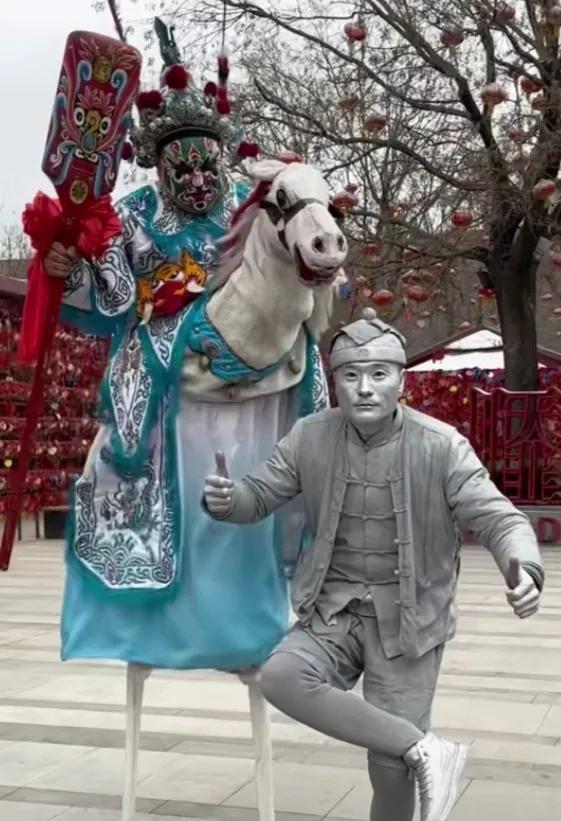 网红雕塑银人阿少,他全身涂满银色,吸引了众多市民观看以及拍照_姐姐