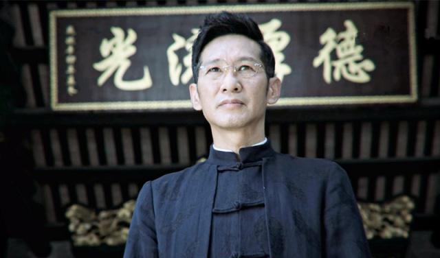 一副黑框眼镜,中山装,擦得锃亮的皮鞋,一丝不苟的头发,就是这样一副