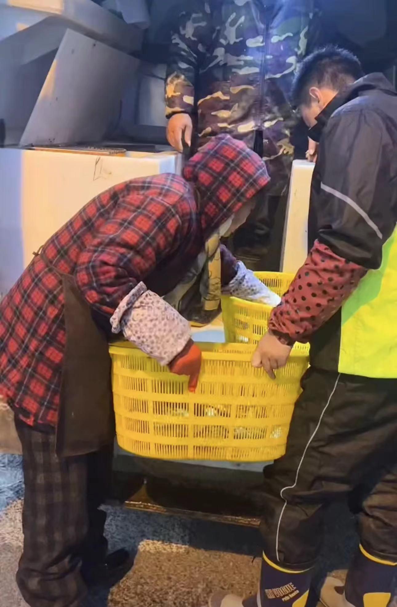 只见李飞穿着黑白相间的高腰雨靴,戴着红底黑点的花色袖套,一副鱼老板