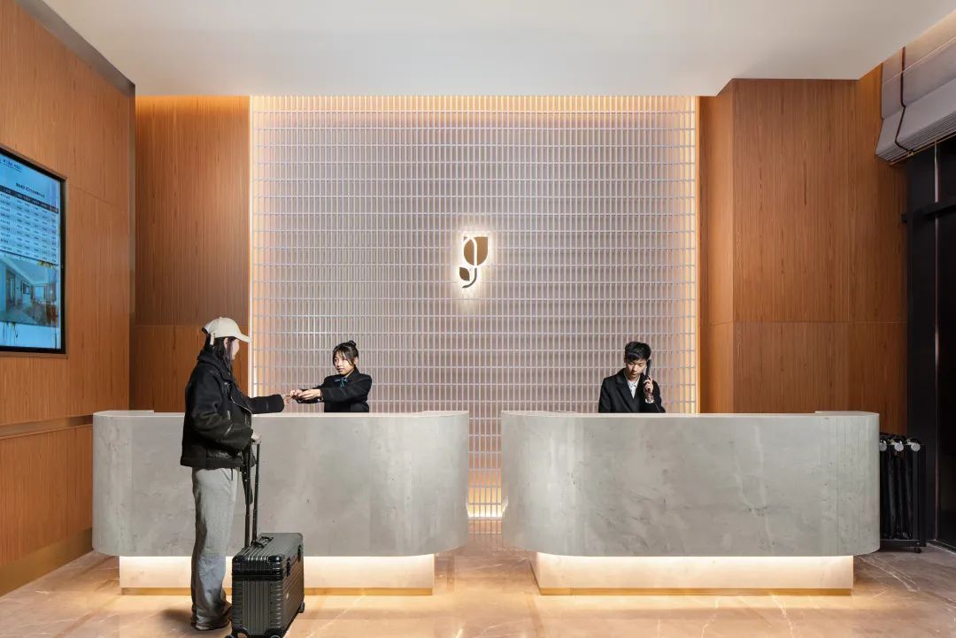 开放式的前台打破了行路匆忙的疏离感,配以简洁线条的背景墙衬映着