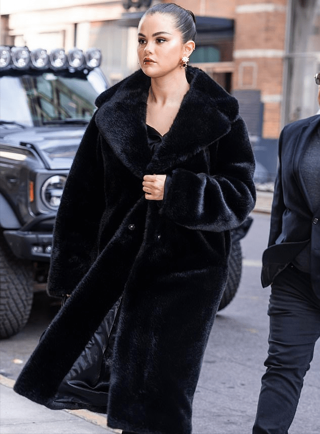 赛琳娜这次的造型非常保暖,超级长款的皮草,内搭黑色礼服裙,其实赛