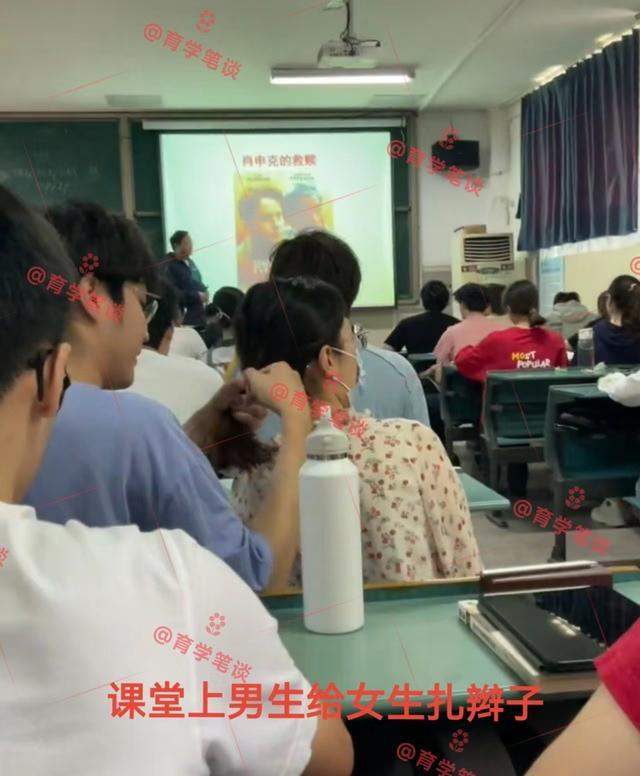 一高校男生给女友扎头发,后面女生倍感不适,黑板上的课题很应景