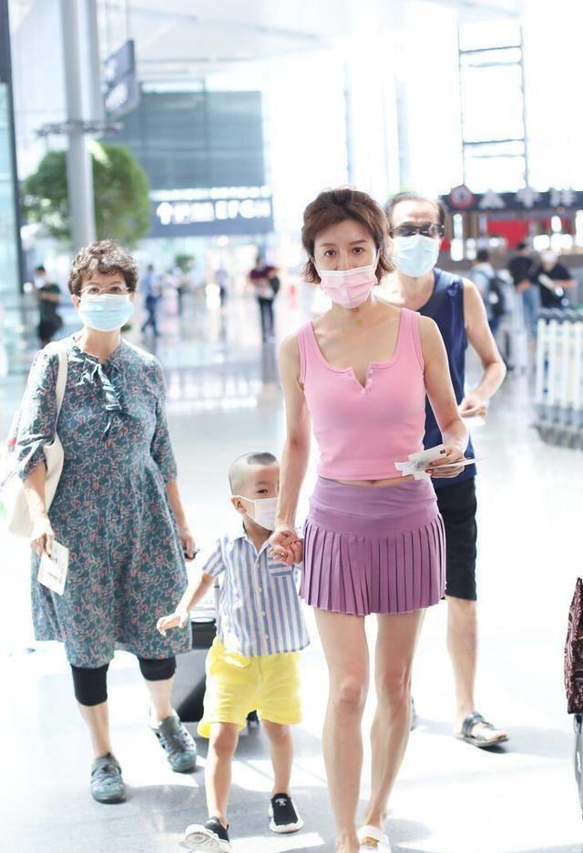 45岁阔太金巧巧骑电动车接地气,短裙带儿子走机场,身材太火辣_小孩子