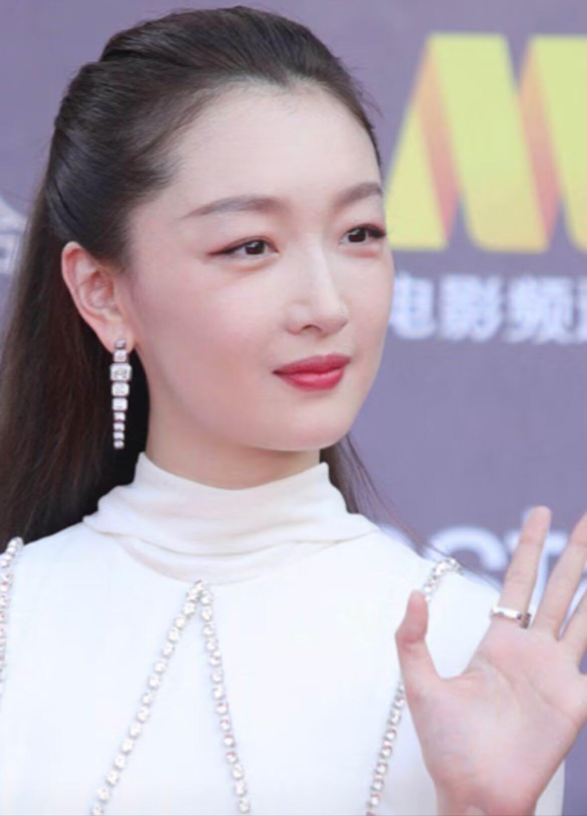 这条白色长裙是半高领的设计,显得周冬雨的脸型比较饱满大气,肩部增添