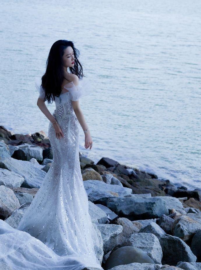 身着人鱼裙的李沁展现出姣好的身材,长发被海风吹起,优雅飘逸_漂亮