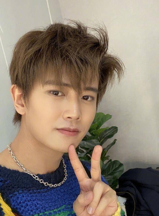 画面中张艺兴一边跟朋友散步聊天,一边抽烟,看起来十分熟练