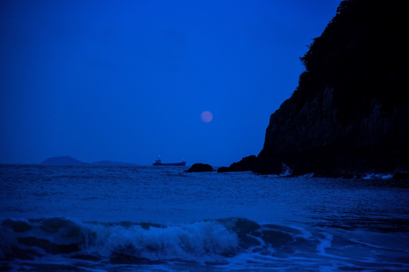 即将离开时,正巧一轮暗红色圆月高悬于半空,出于断崖山石之上,徘徊于