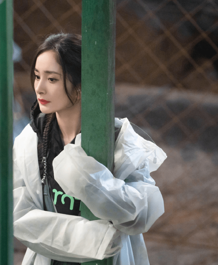 杨幂最新路透照,女助理蹲下为她穿鞋,另一位助理手拿剧本扶着她_明星