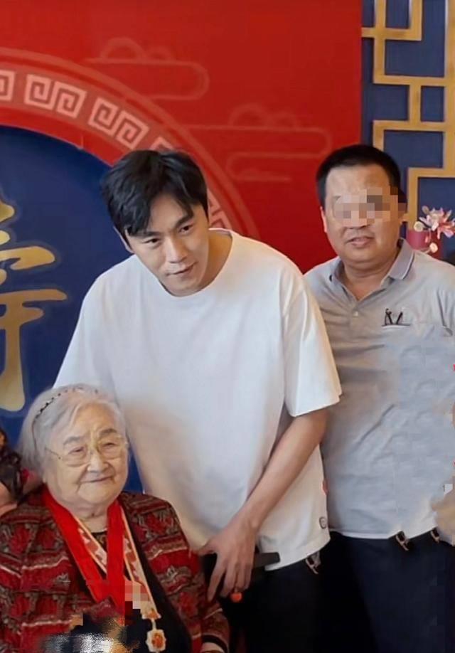 秦昊穿着白色的体恤下身穿着黑色的长裤,拿着麦克风,向来参加生日派对