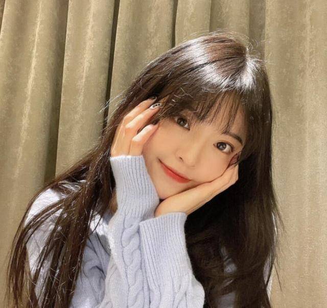 照片中,王文也披散着长发,穿着淡蓝色毛衣,化着精致妆容,做了精致的