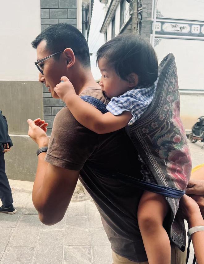 王羽佳用一块布将女儿包裹起来,瞬间朴实的气息扑面而来.