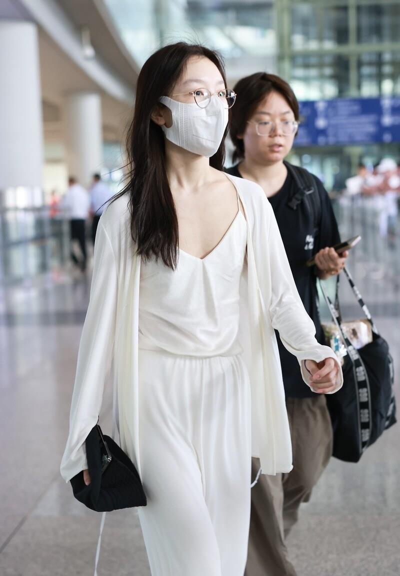 周冬雨现身北京机场,身穿白色开衫搭配v领吊带裙,简约优雅