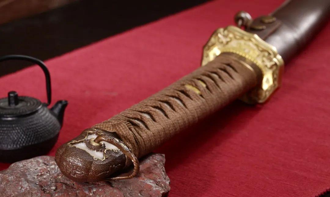 而95军刀的刀柄,手工缠绕绕绳,并用黄铜制作出的樱花目钉固定在手柄的