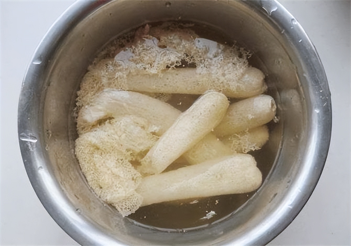 再次清洗:将去掉菌盖和竹荪头的竹荪放入清水中,搓洗至水变清澈.