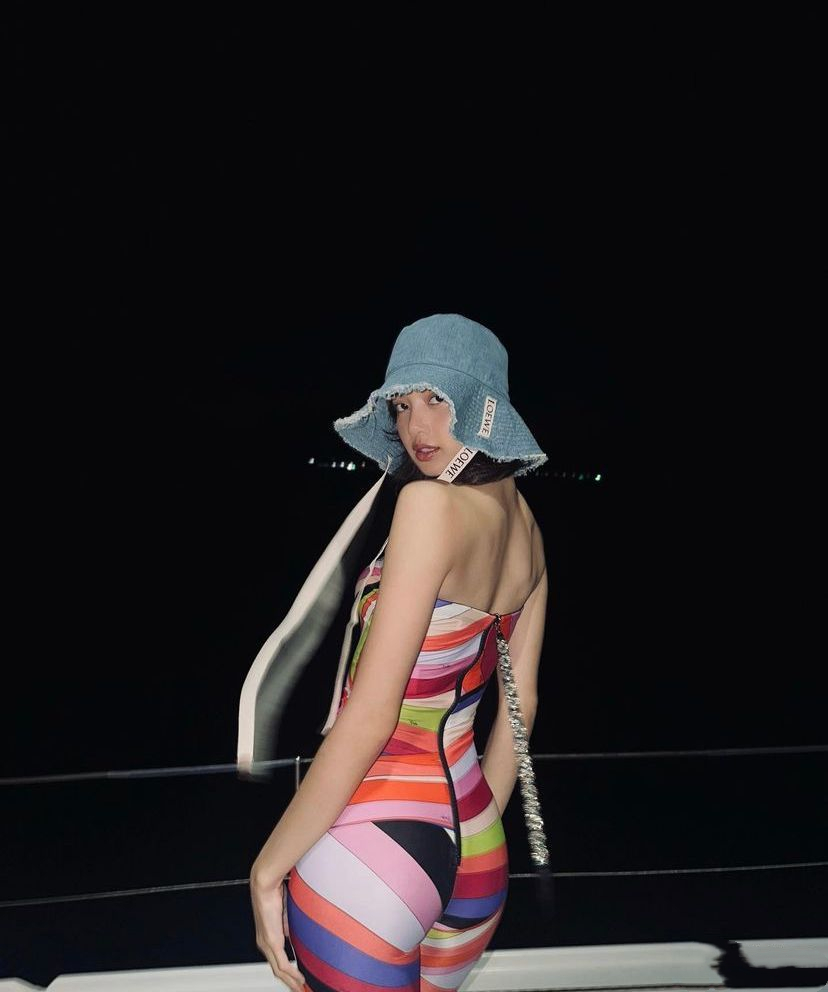 五颜六色的后背带拉链包臀连体衣搭配天蓝色渔夫帽,显得有些冲突