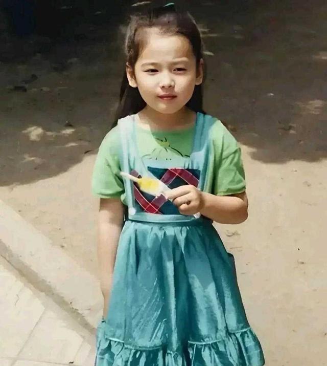 网上流传了一张宋慧乔的童年照片,照片中她穿着蓝色裙子,手里拿着