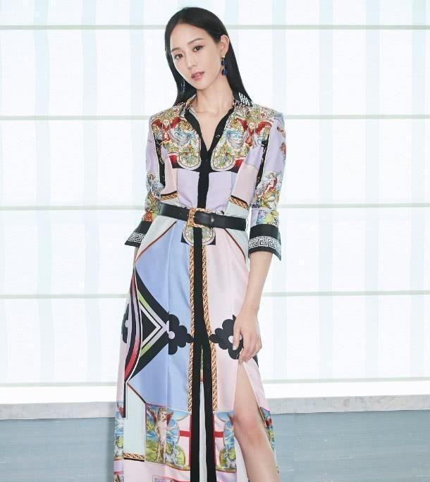 张钧甯身穿一件红色的长裙,脚踩黑色的凉鞋,裙子颜色鲜艳衬托出张钧甯