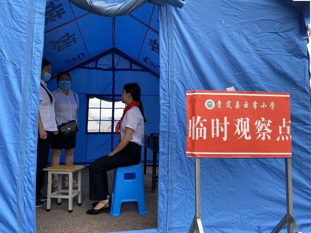 贵定县云雾小学在校门口处设立了三个入校通道,每个通道均有一位值班