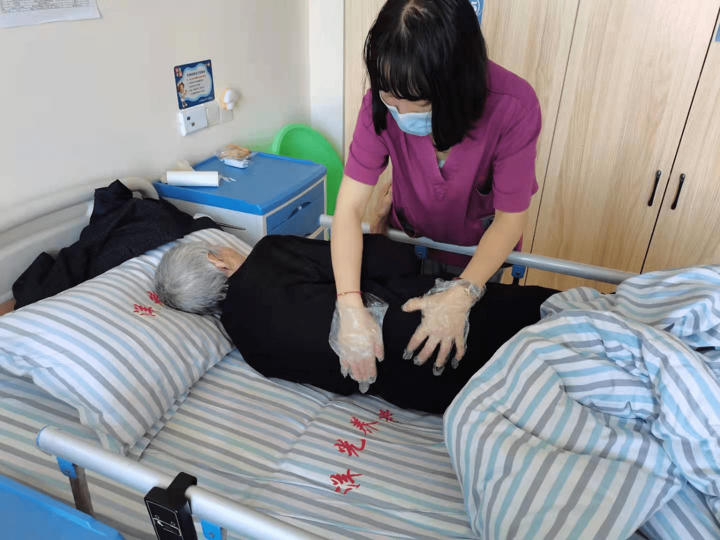 护理员为老人翻身拍背