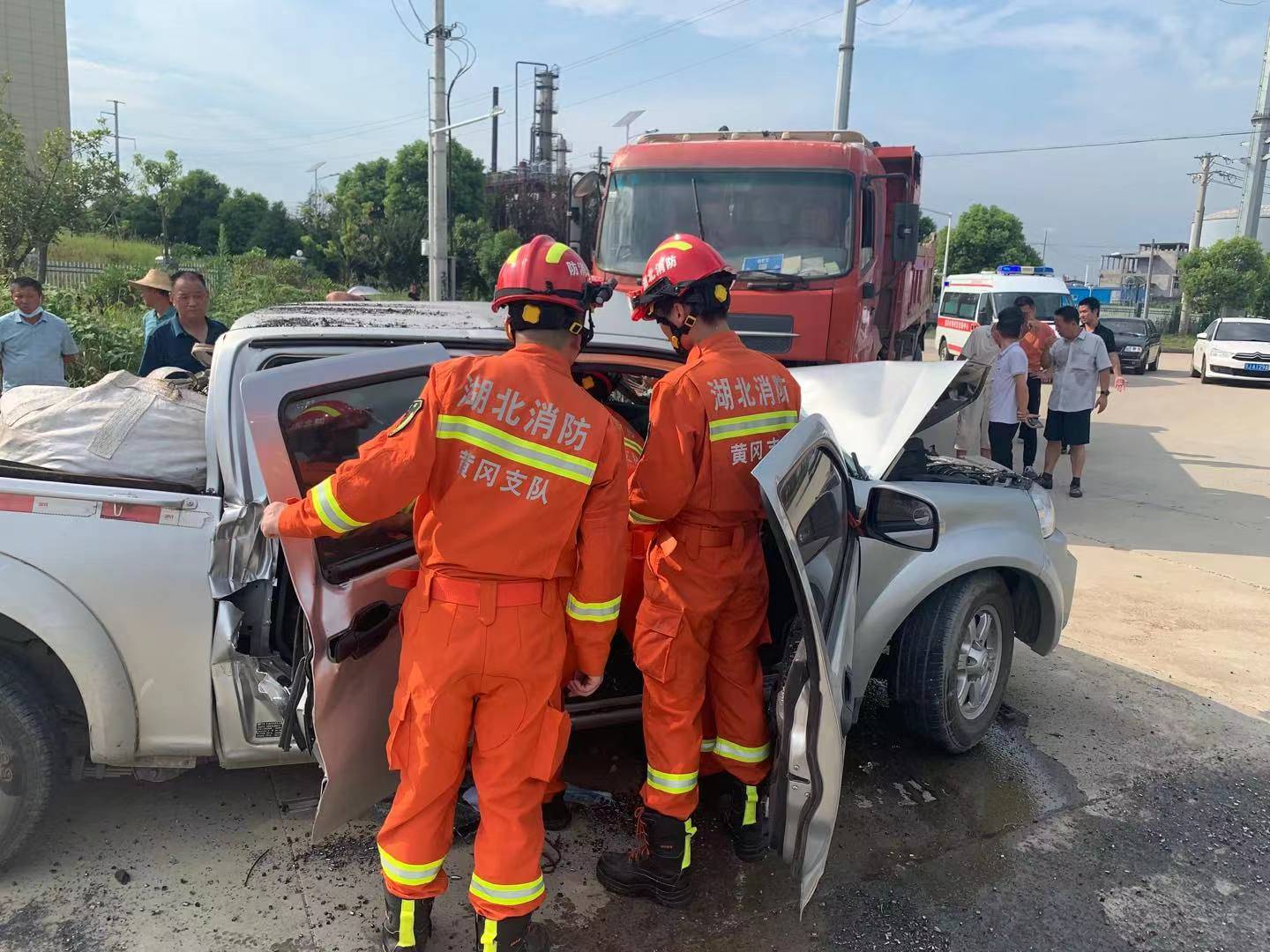 大货车呈逆行状停在道路一侧,皮卡车车头深陷驾驶室,驾驶室严重变形内