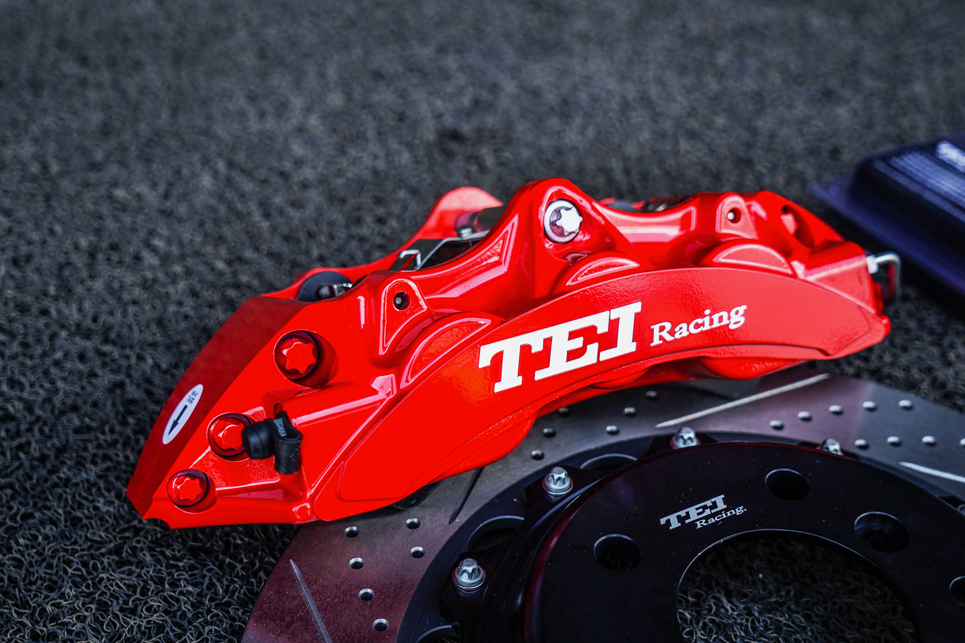 红色大六活塞卡钳,搭配355x32mm打孔划线纹分体盘;tei racing刹车卡钳