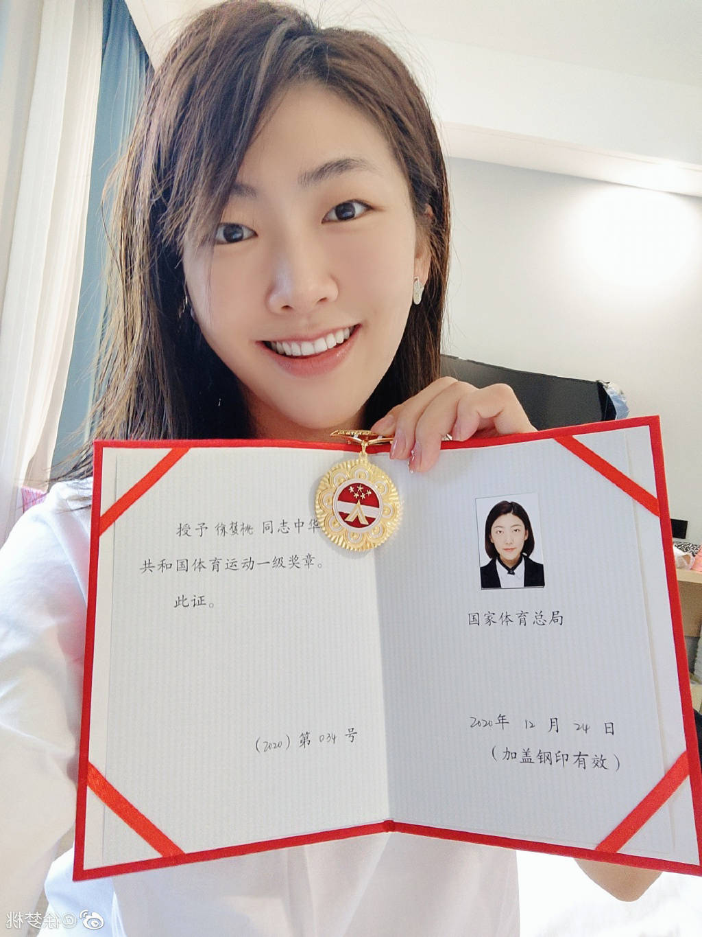 徐梦桃在社交媒体上晒出自己被授予的体育运动员一级奖章和证书