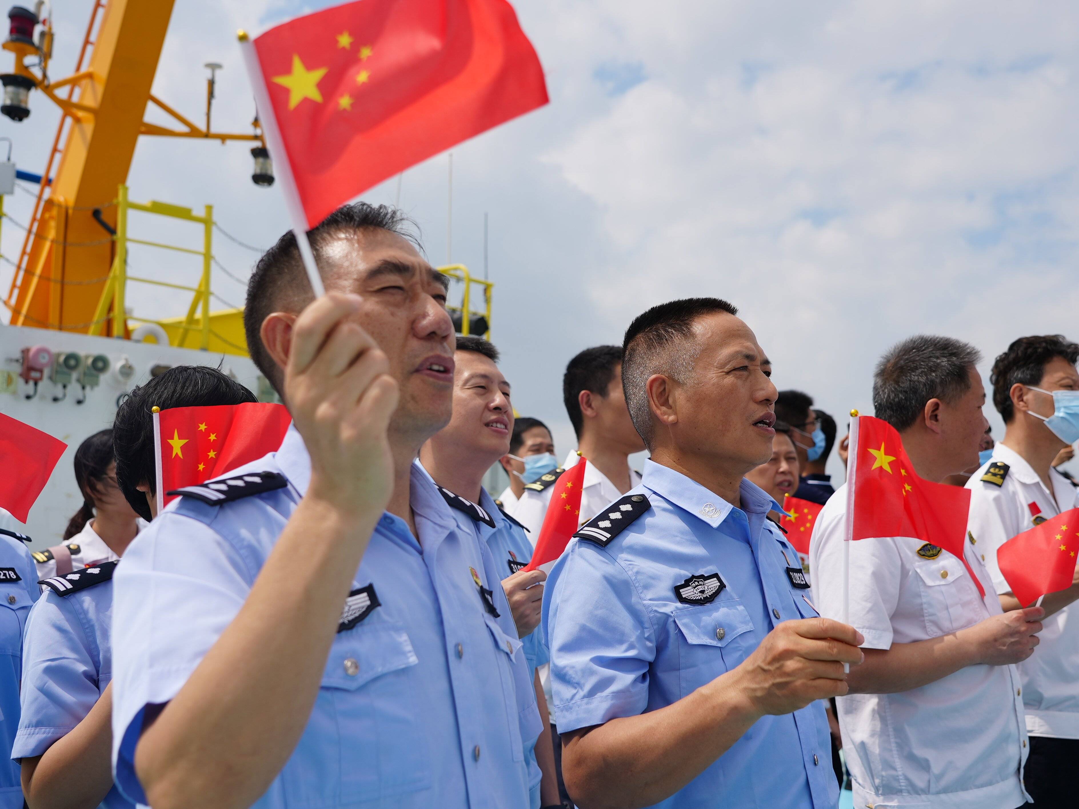 阳光柔情百倍,海风吹过甲板,全体党员面向党旗,举起右拳,重温入党誓词