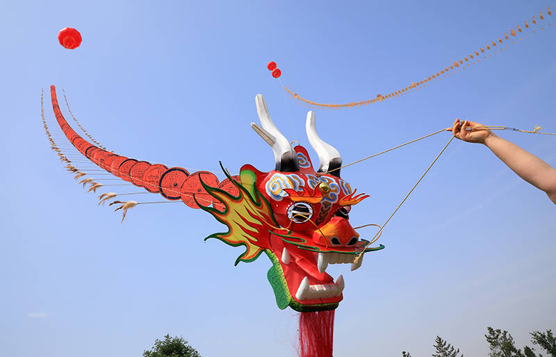 仔细看,这条长龙居然是一只由龙头和一片片瓦当图案组成的巨型风筝.