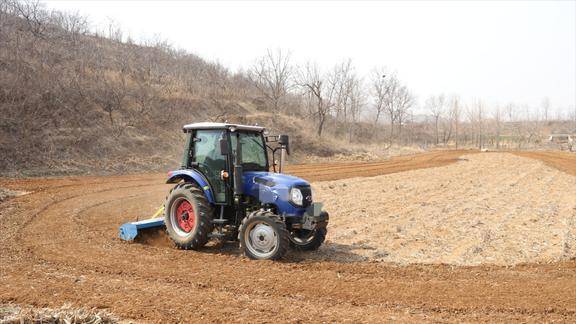 实拍胶东丘陵春耕的场景拖拉机使巧劲转着圈耙地