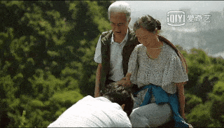 开头主角之一张东升携两位老人登山,并在山顶为两位老人摆脚准备拍照.