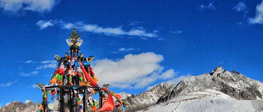 米,站在山口,山风劲吹,蓝天白云下,五彩经幡在大地与苍穹之间飘荡摇曳