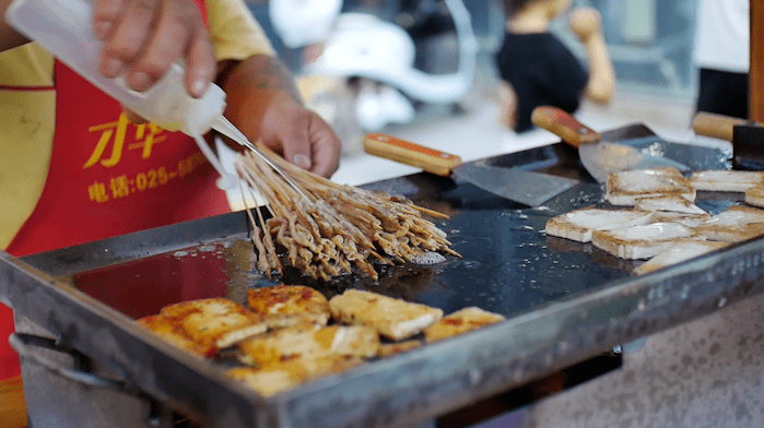萧县夜幕降临,熙熙攘攘的摊贩遍布整条街道,竖起铁架,拉上电灯,铺开