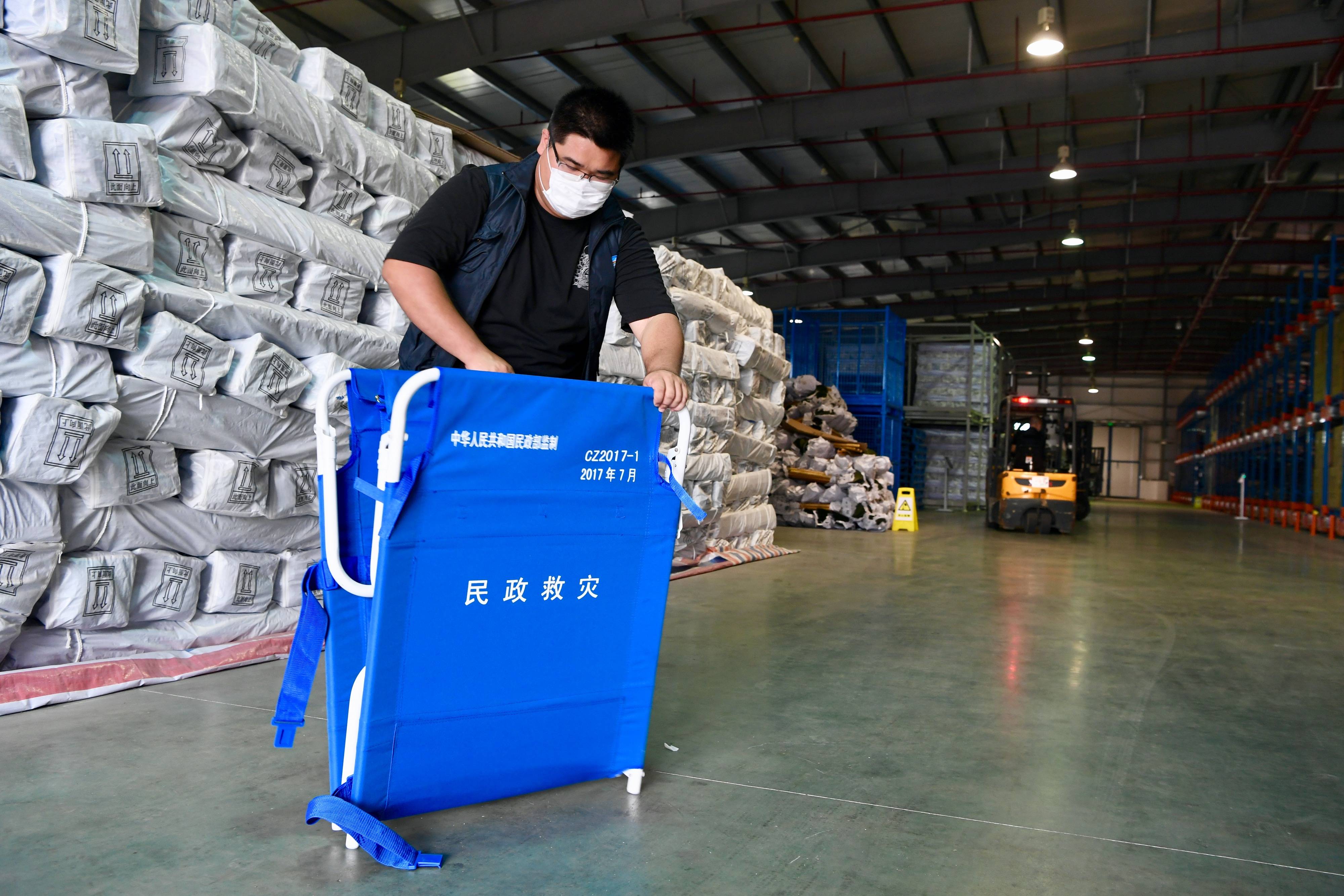 7月10日,福建省救灾物资储备中心工作人员在检查救灾专用折叠床.