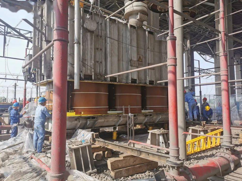 上午9时,完成上述准备工作后,吊车通过倒链将变压器钟罩缓缓拉起,露