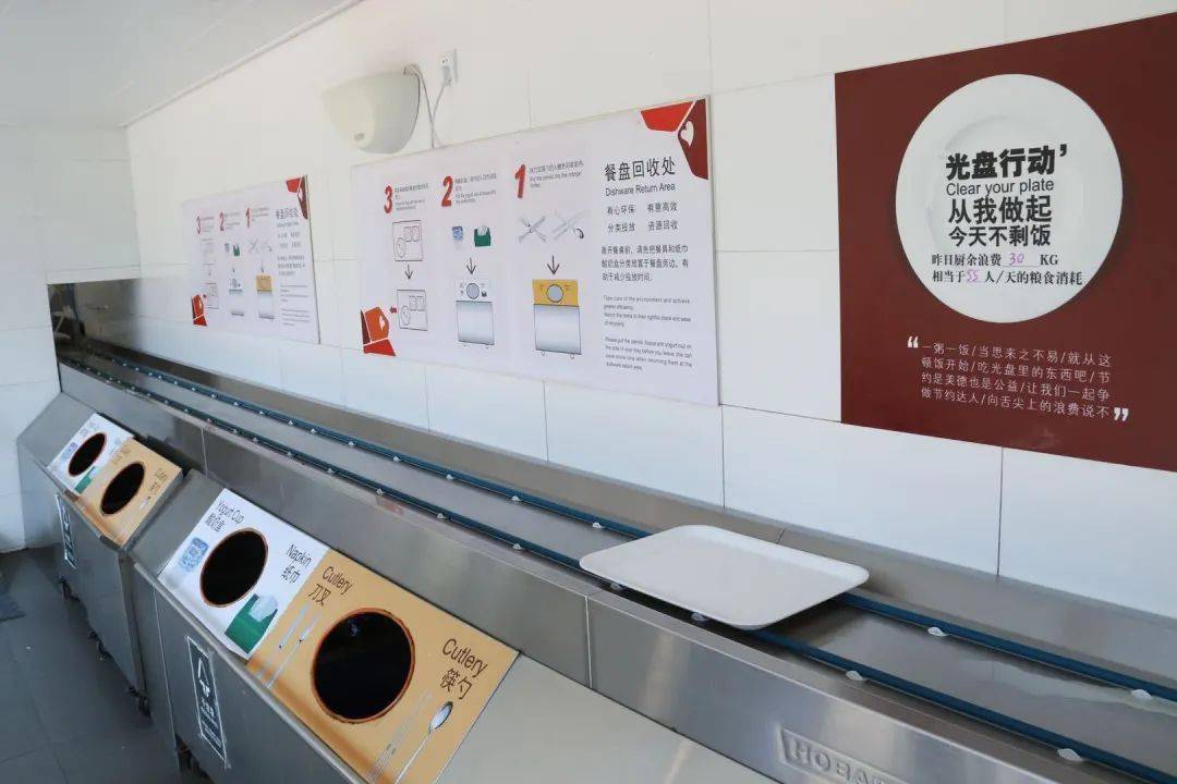 在联合利华的员工食堂,餐盘回收处放置了一块写着"光盘行动从我做起"