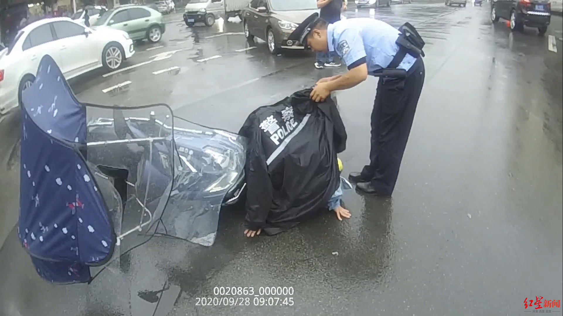 辅警脱下雨衣为伤者挡雨.