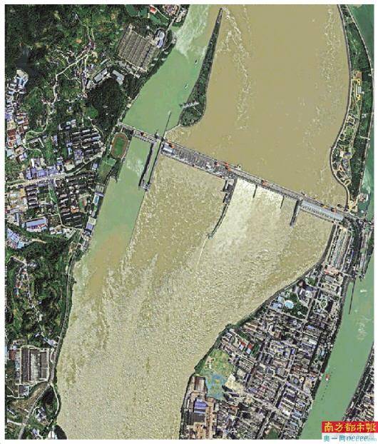 葛洲坝,大坝泄洪情景清晰可见,水流汹涌,与旁边船闸平静的水面形成