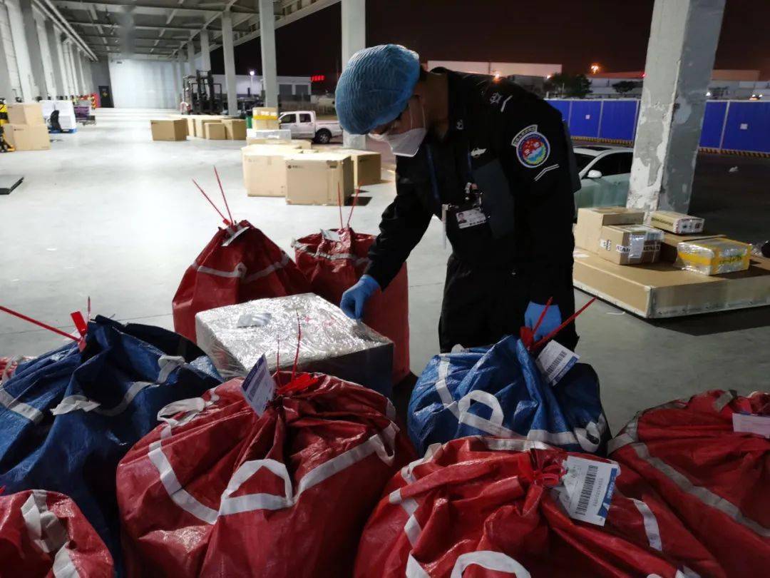 堆积如山的货物在有序的接受着检查夜幕下,首都机场的货运安检现场