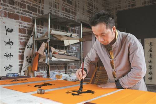 吴长兴精心为客户创作书法作品.