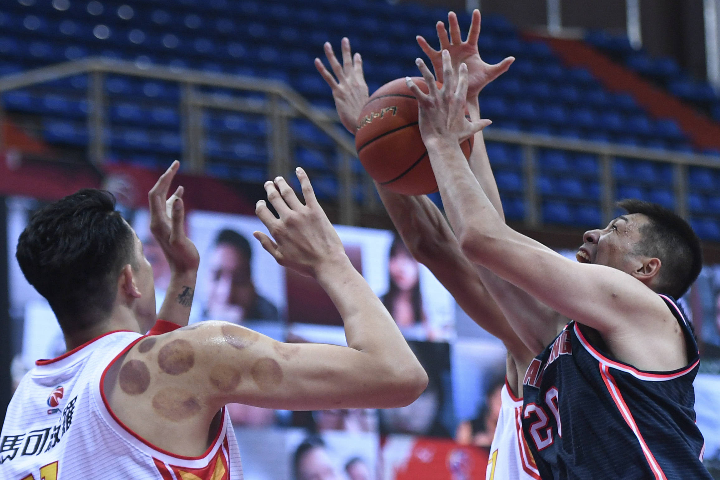 10月20日,广东东莞大益队球员任骏飞(右)在比赛中争抢篮板球.