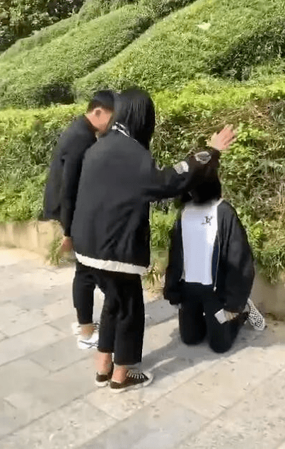 气愤平乐一男和两女围着一位下跪的女孩不停对其扇耳光
