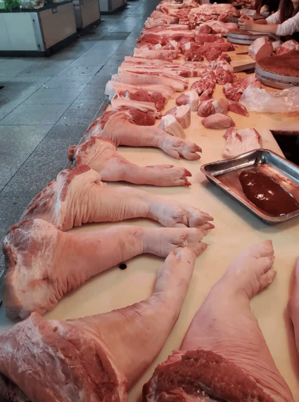 "在市区府前菜场,猪肉摊的周女士卖力地向顾客吆喝.