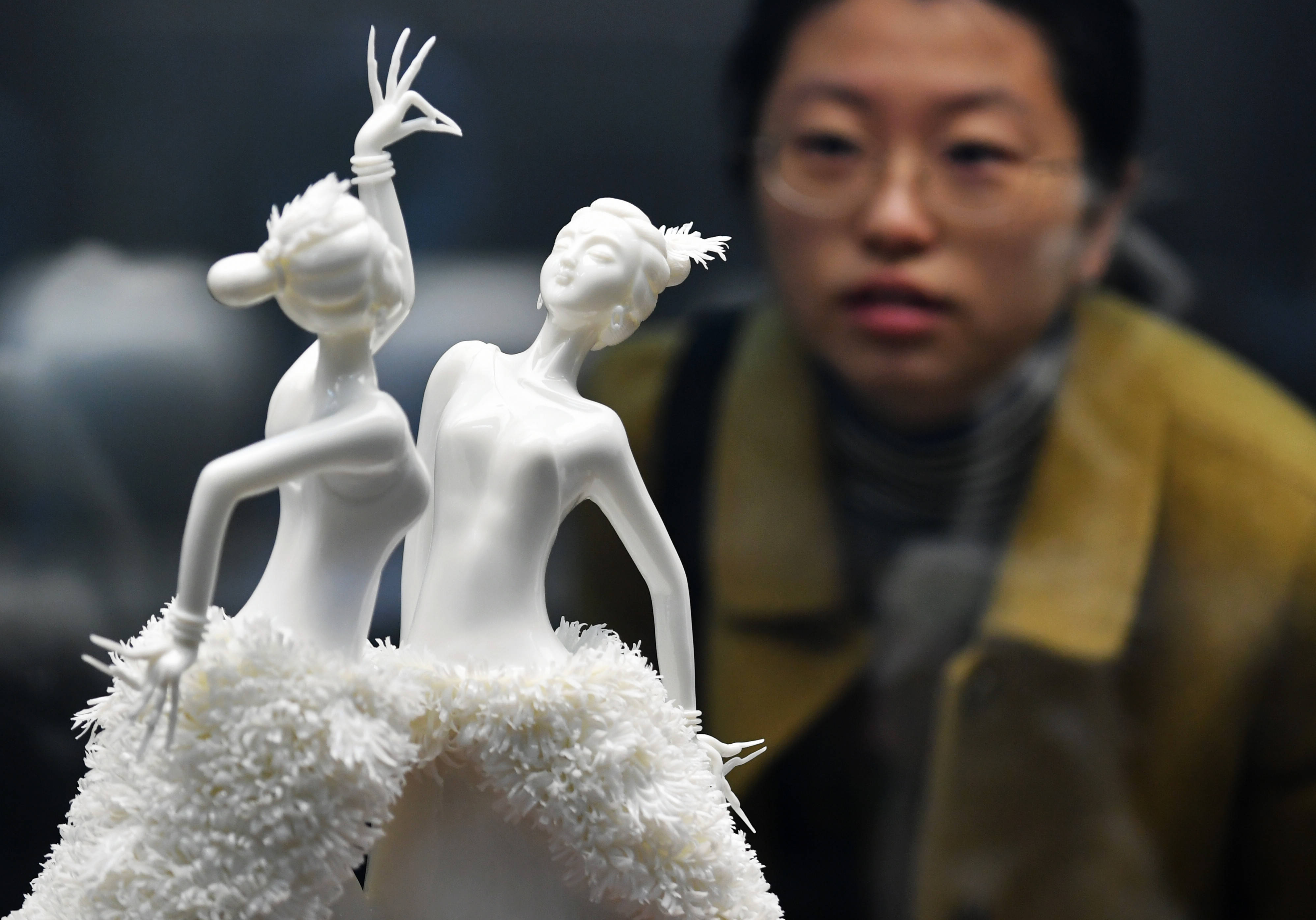 12月16日,一名观众在欣赏中国陶瓷艺术精品《雀语吉祥》