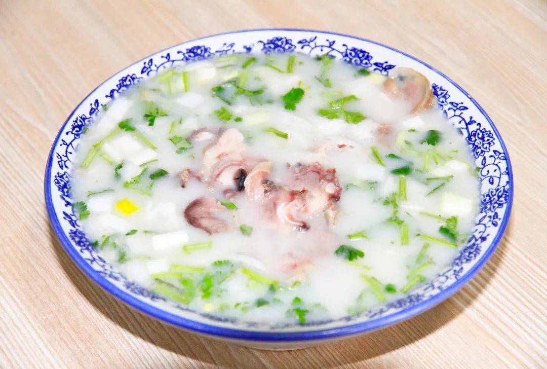 一碗肉香汤鲜的羊汤就可以上桌了点缀上葱花,香菜配上现切的羊脸肉浇