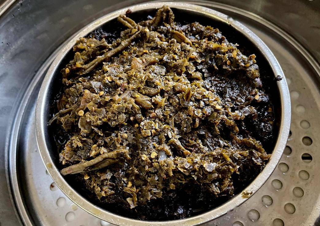 很多人没有见过吧,这是"羊奶菜扣肉",最有滋味的一道菜,还没有扣过来