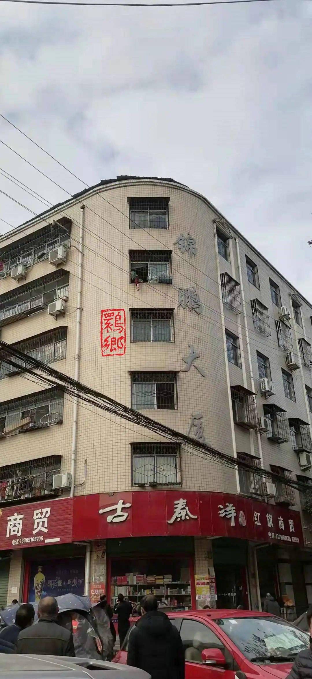 工农街十字时,无意中看到大家都在朝十字西南角的锦鹏大厦五楼上观望