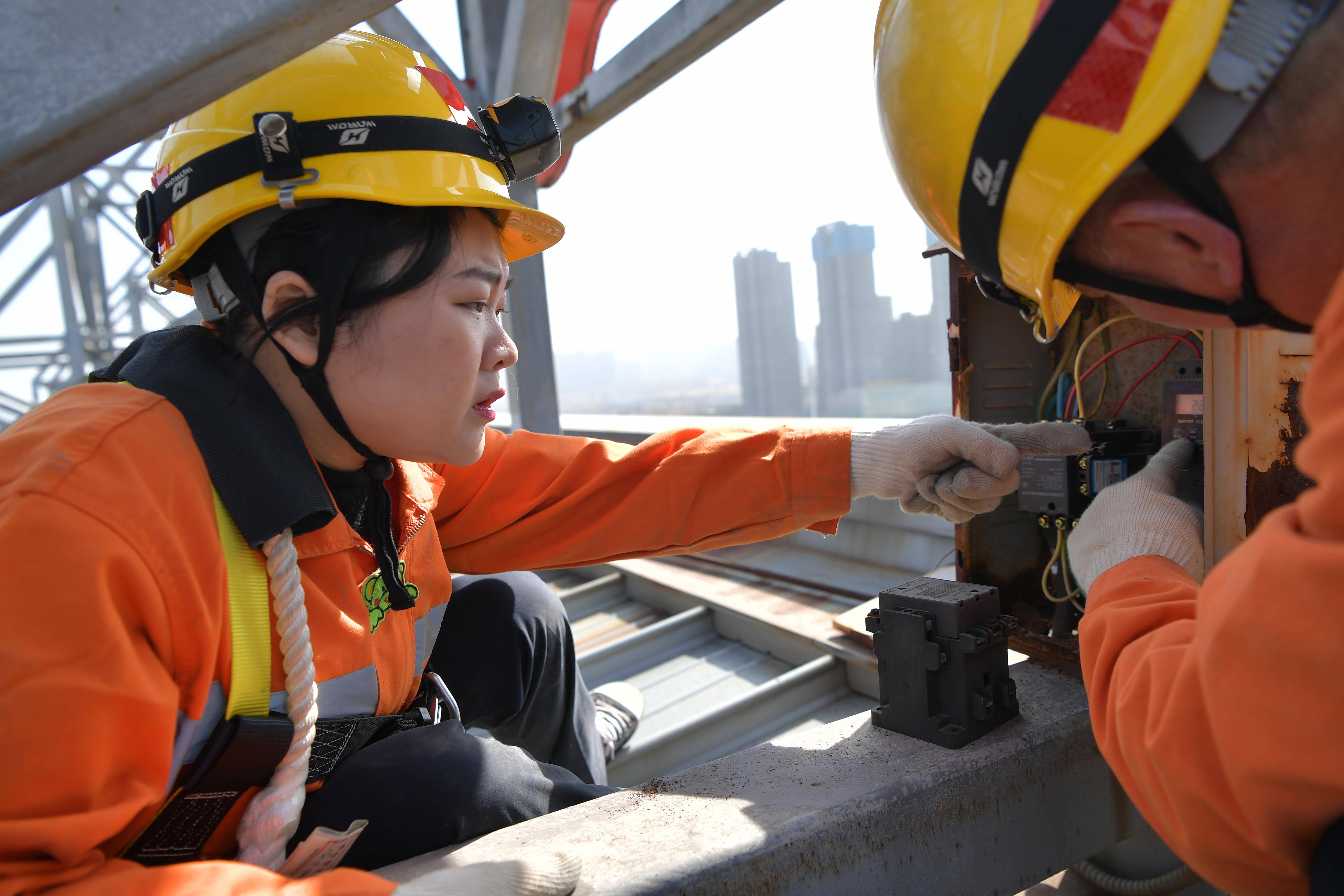 在南昌西站站房顶部,电力工人检修电力设备(1月29日摄).