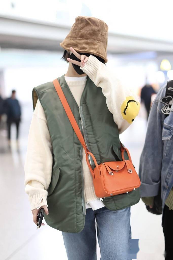 杨丞琳穿军绿棉马甲现身机场 戴条绒渔夫帽挎小包简约时髦